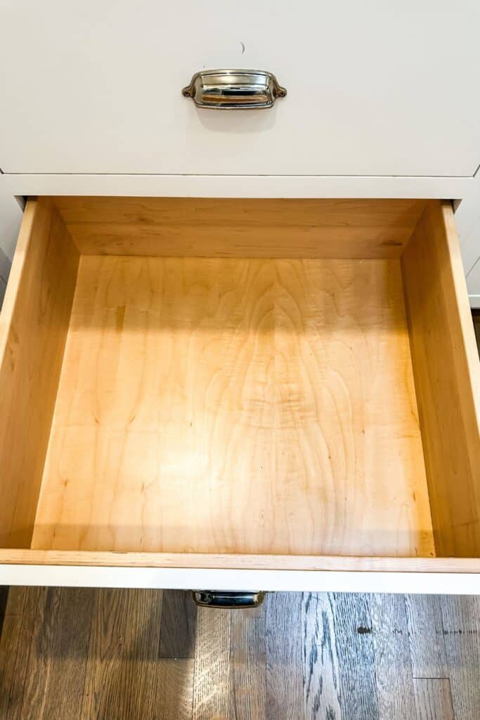 An empty drawer that has been cleaned out and wiped down.