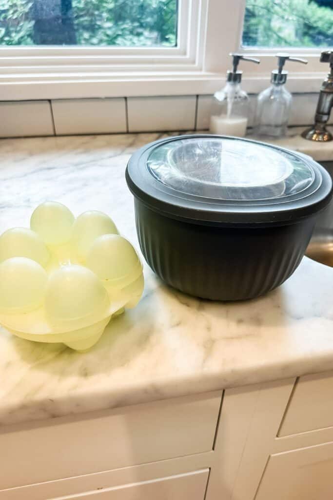 An egg jello jiggler container and a large gray plastic container sitting on my marble countertops.