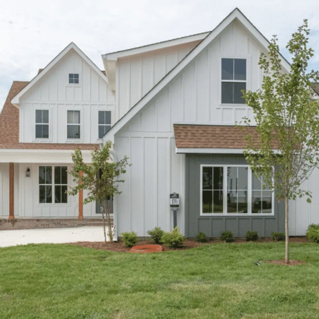 Snowbound on the exterior of a home with a brown roof and a dark gray area of windows on the front.