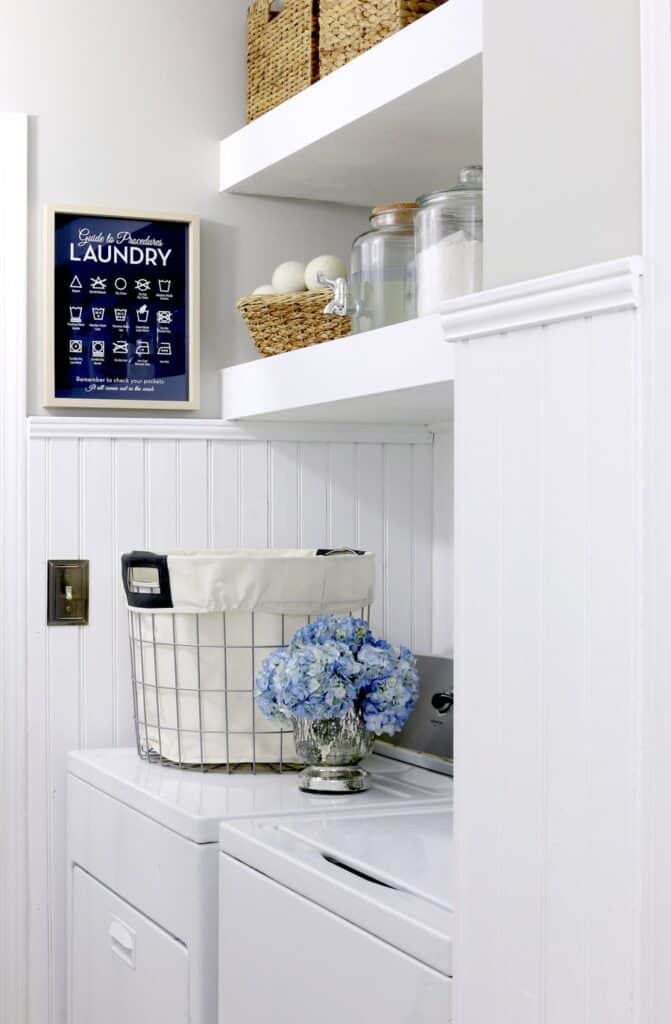 A laundry room with white beadboard wainscotting.