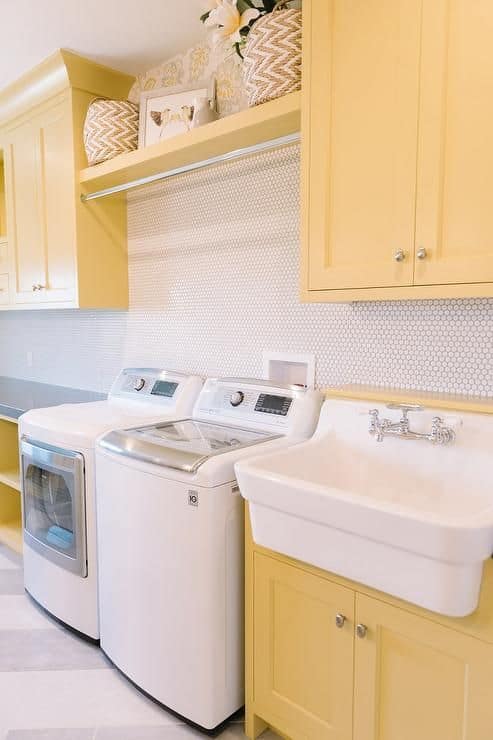 A laundry room with bright yellow cabinets.
