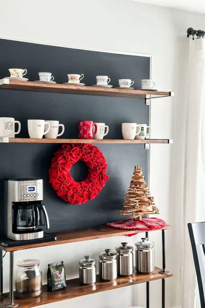 a coffee bar with a red felt wreath and wood christmas tree.