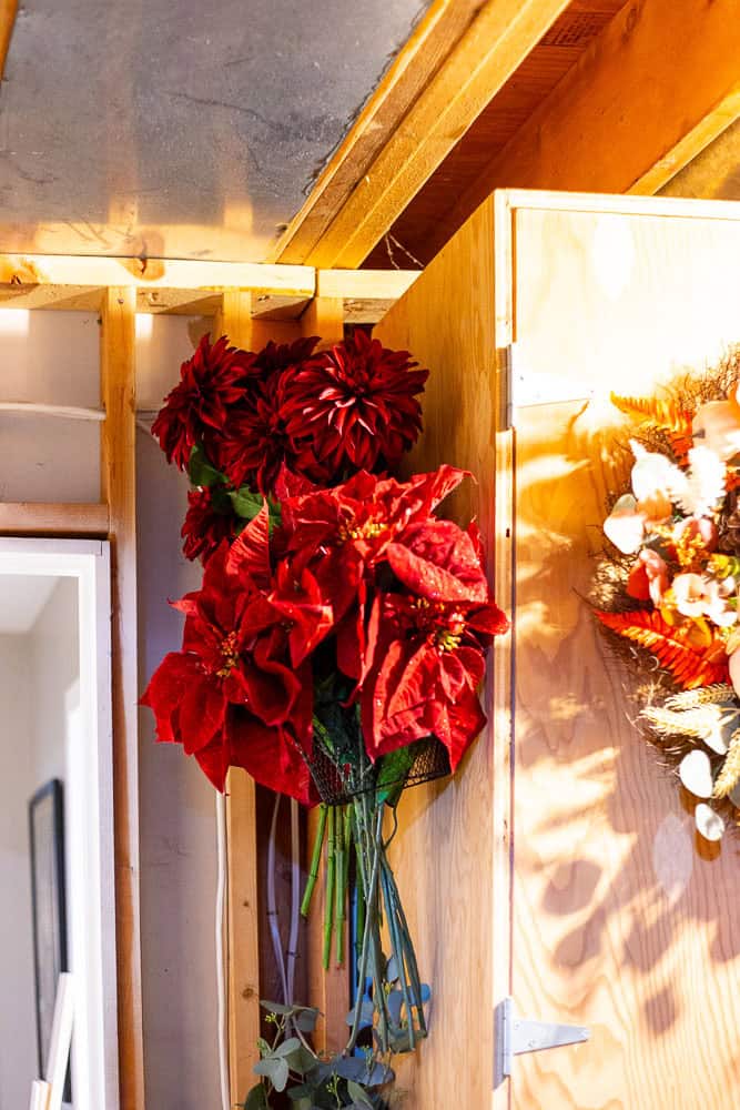 Hanging faux flowers on the side of a wood cabinet in my storage room.