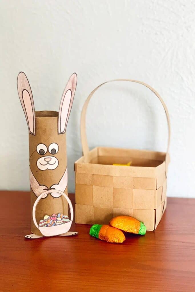 A toilet paper tube crafted to look like a rabbit holding a basket.