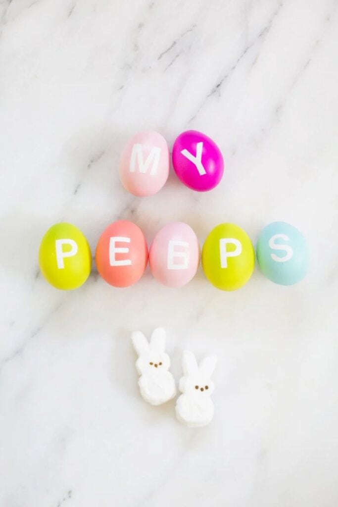 Plastic Eggs with letters on them and two Peeps.