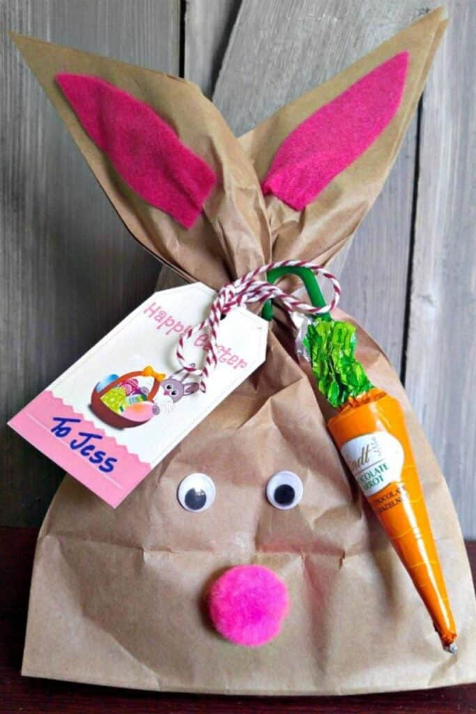 A brown paper bag crafted to look like a bunny with a name tag.
