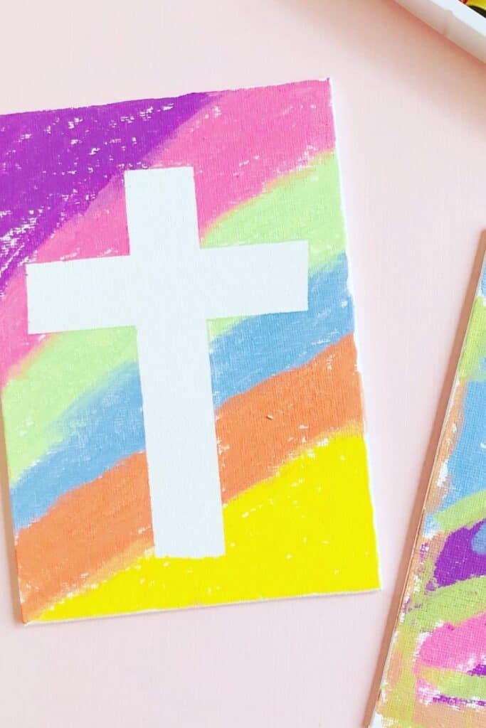 A cross on a canvas with lots of different colors.