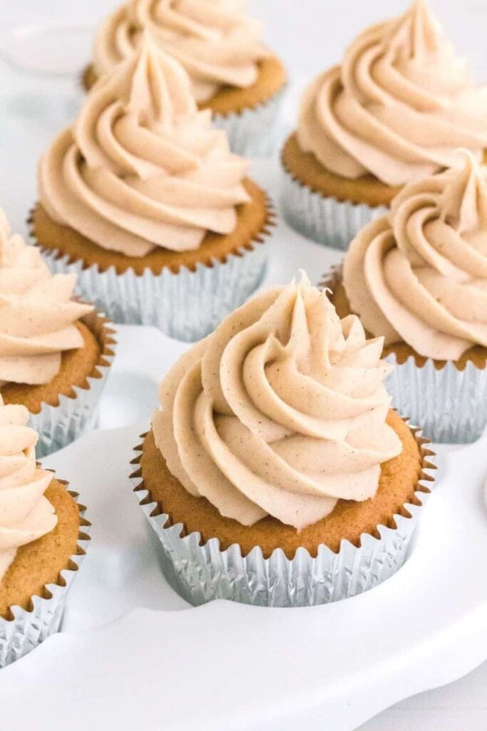 Cupcakes in a silver paper cutting with a cinnamon cream cheese topping.