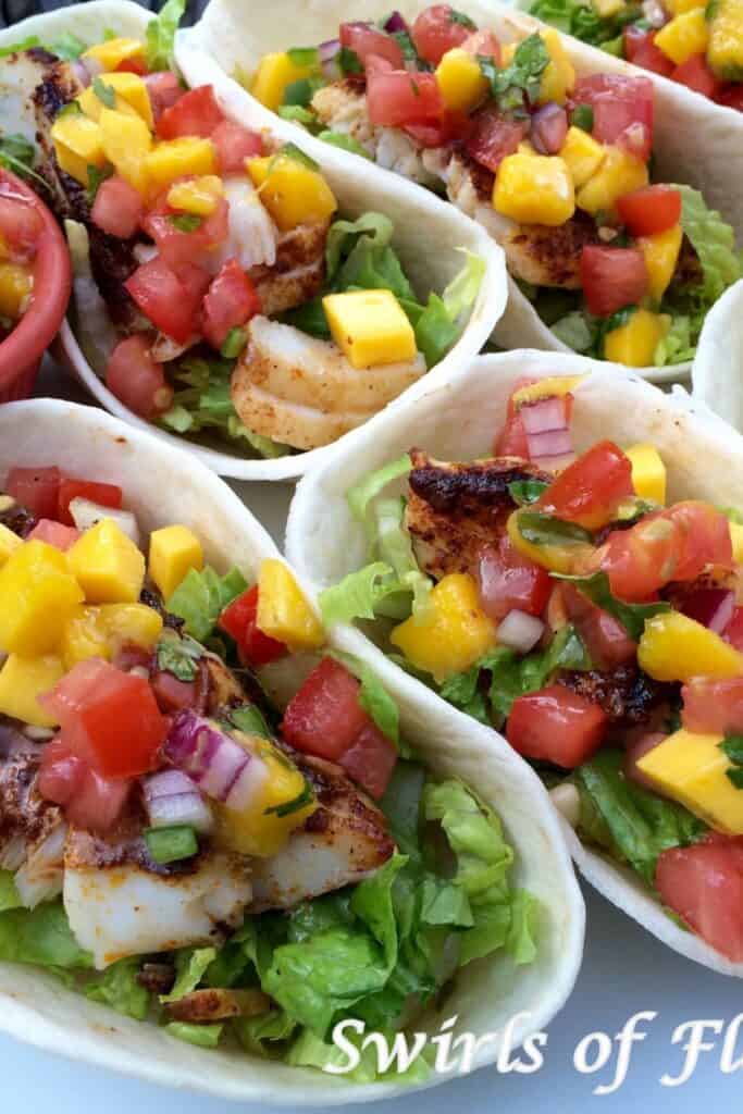 Several fish tacos with a mango salsa.