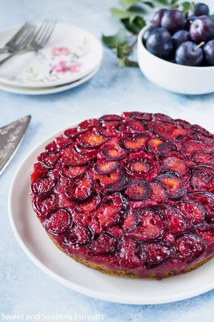 Plum upsidedown cake on a white plate.