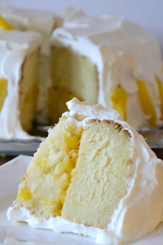 peach and prosecco cake with white icing on a white plate.