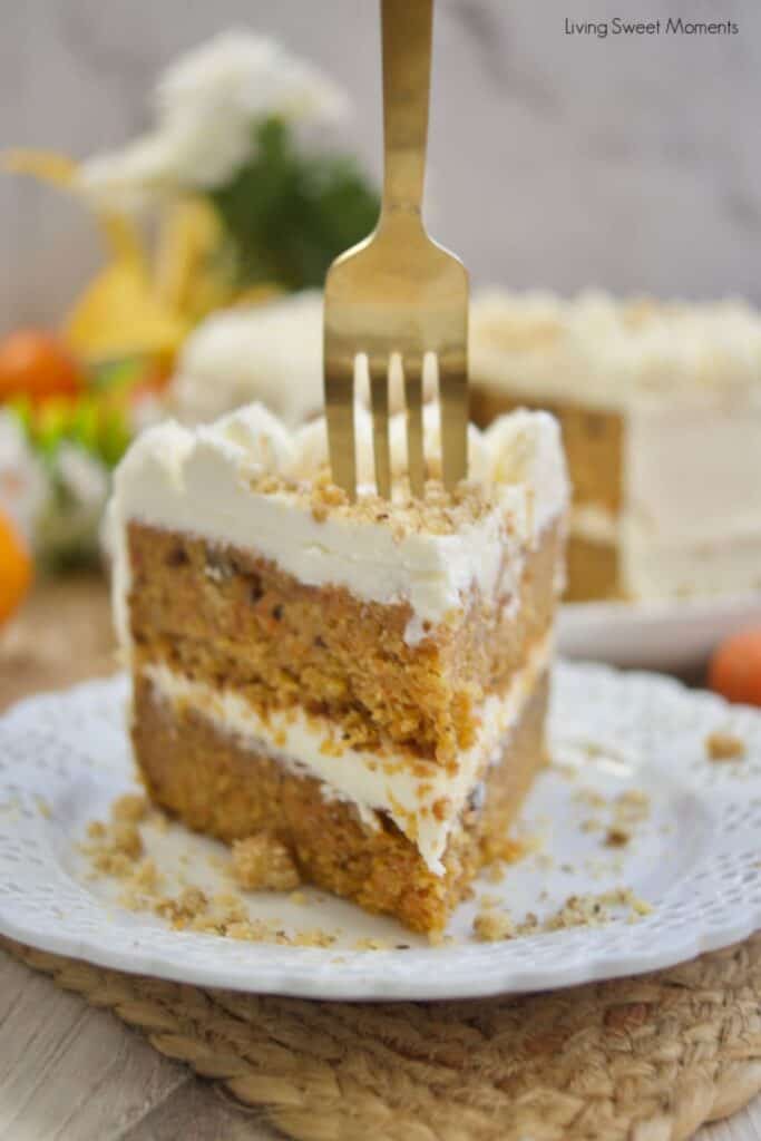 A slice of spiced orange ginger cake on a white plate with a fork in the top.