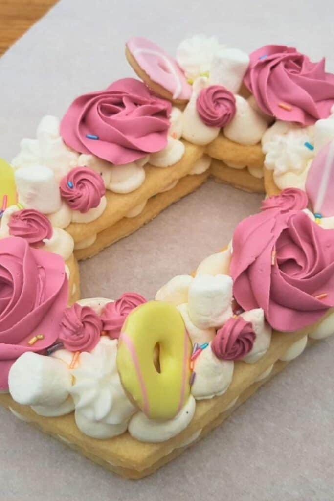 Cookie cake in an oval with roses made from pink icing on top.