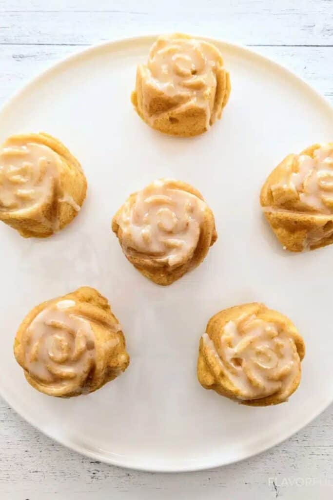 Mini bundt cake in the shape of a rose on a white plate.