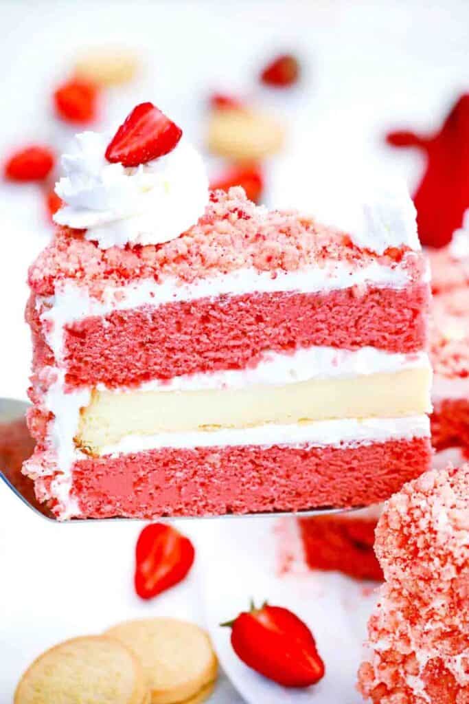 stawberry crunch cake with a dollop of whip cream and sliced strawberries.
