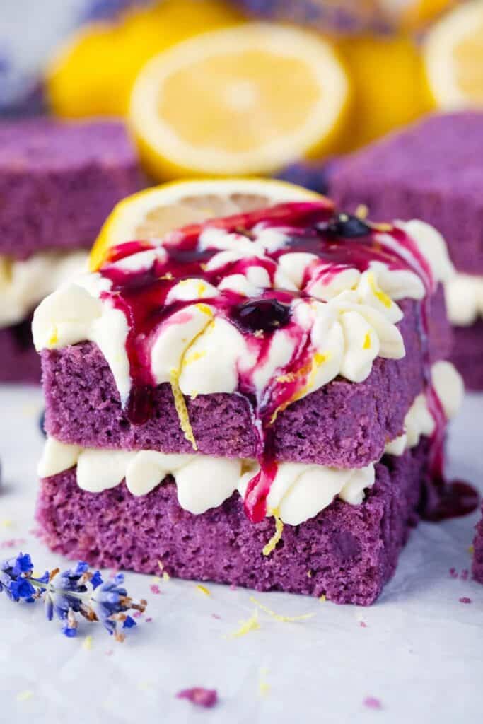 purple cake with lemon buttercream icing between slsices of cake and on top.