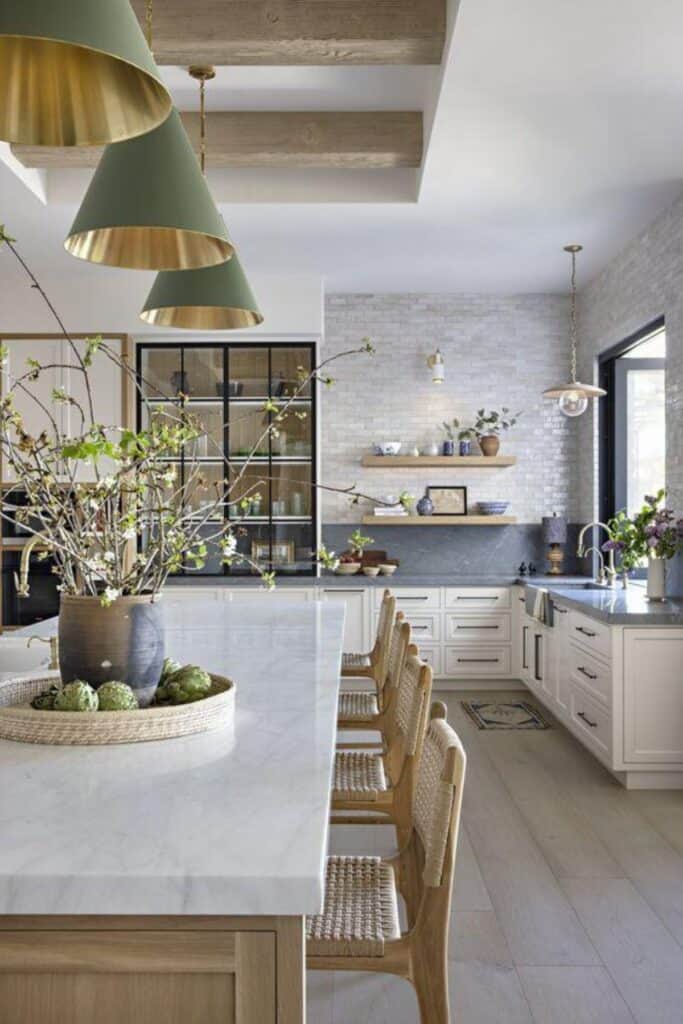 White cabinets with gray counters with a gray backsplash, floating shelves and woven bar stools.