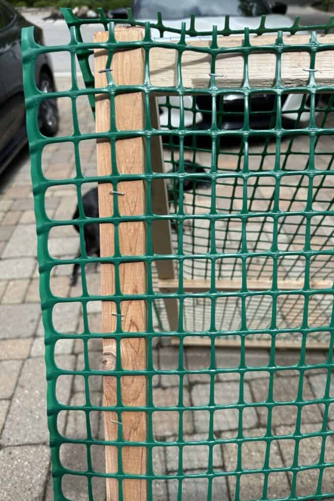 The fencing being attached to the frame with staples.