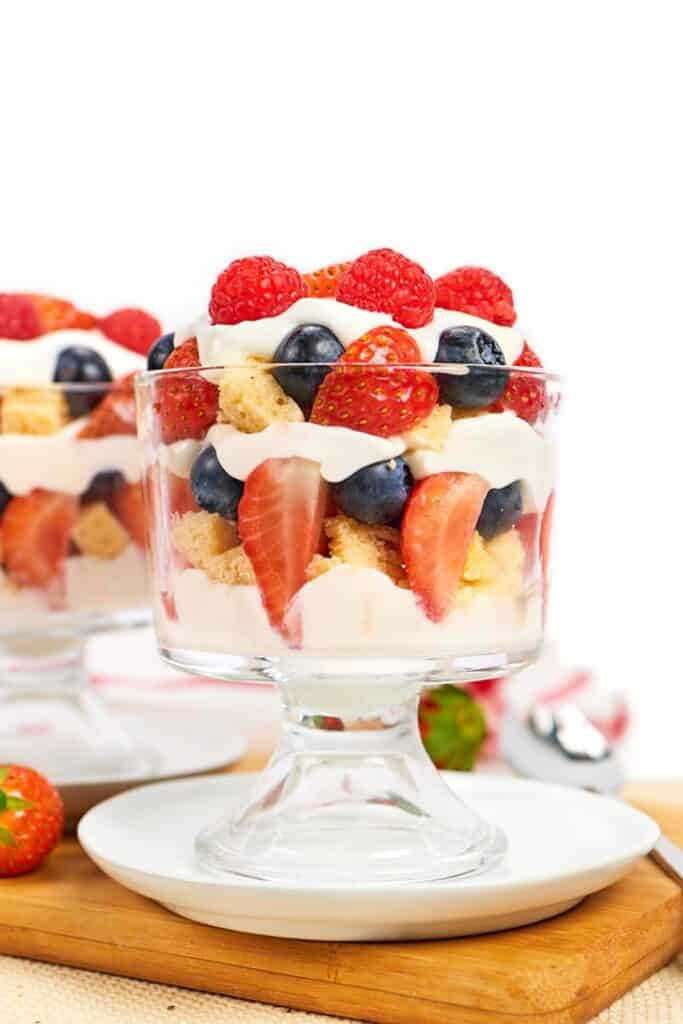 Greek yogurt with strawberries, blueberries, raspberries, and protein cake layered in a trifle dish.
