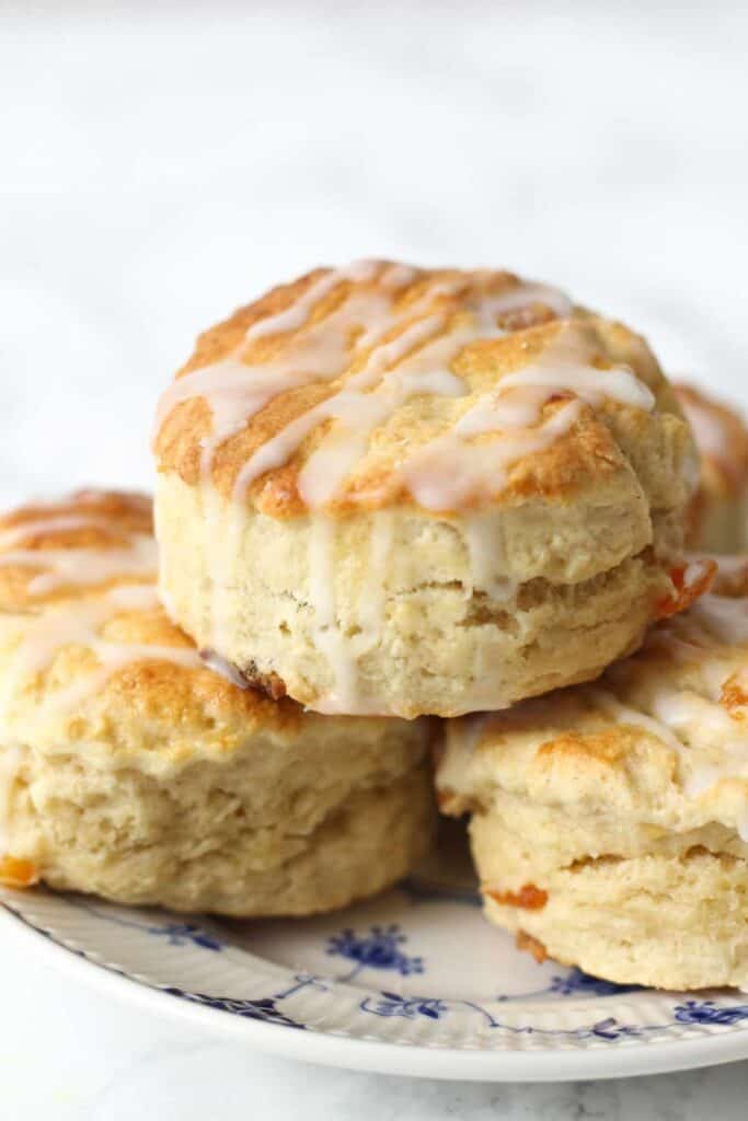 stacked up apricot scones on a blue and white plate.