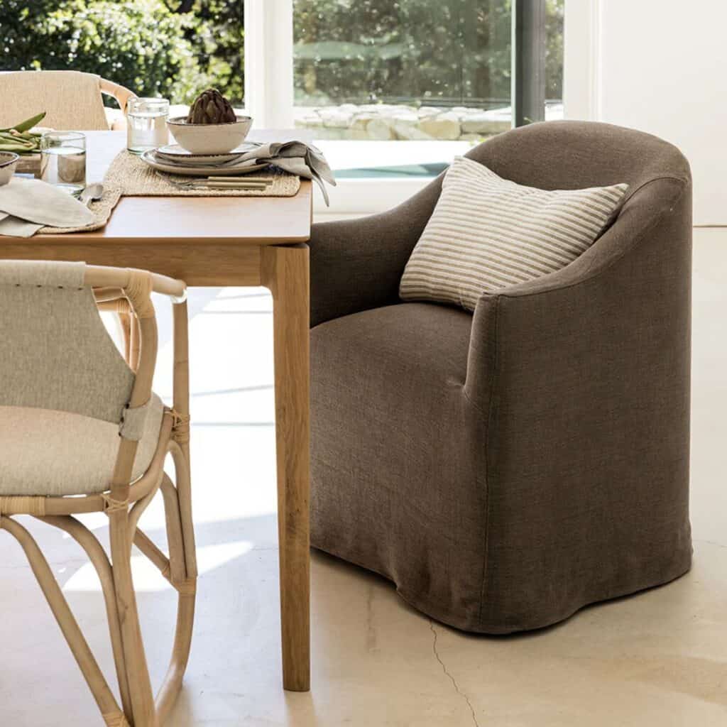 A wood dining table with a gray upholstered chair at the head.