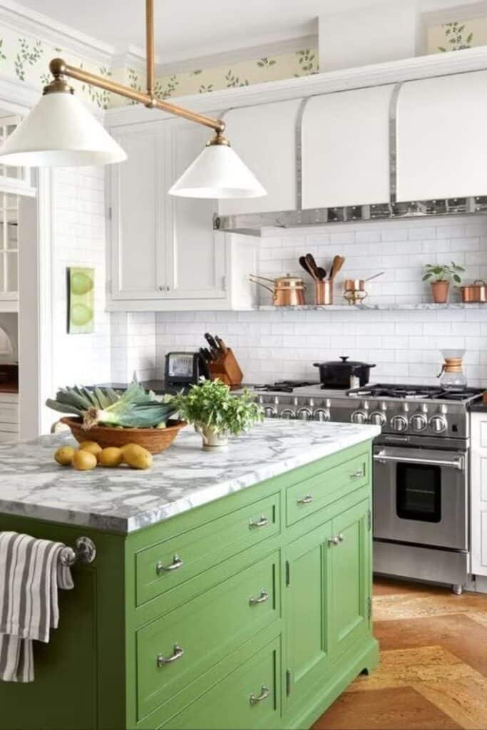 A kitchen with white perimeter cabinets, a green island, and wallpaper above the upper cabinets.