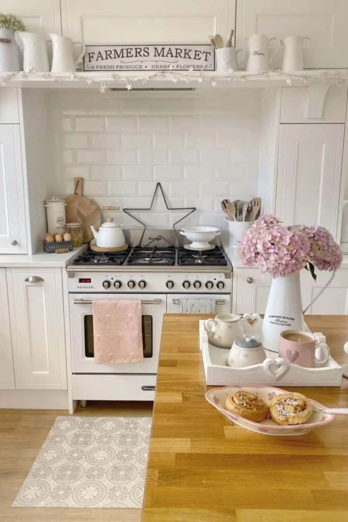 A hwite kitchen with a sign above the stove that says farmers market and whtie pitchers.