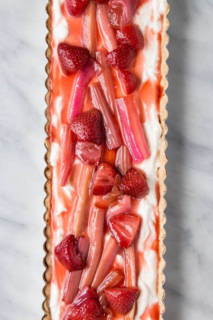 strawberry rhubarb tart in a rectagular dish on a marble surface.