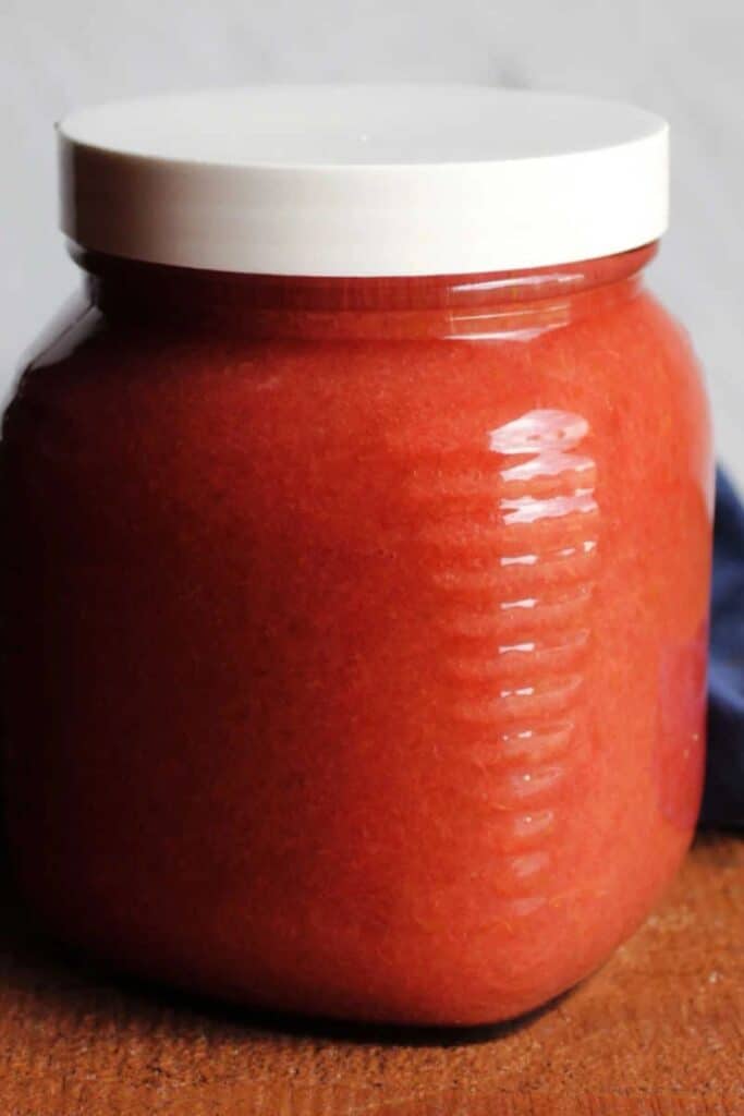 Strawberry rhubarb applesauce in a jar with a white lid.