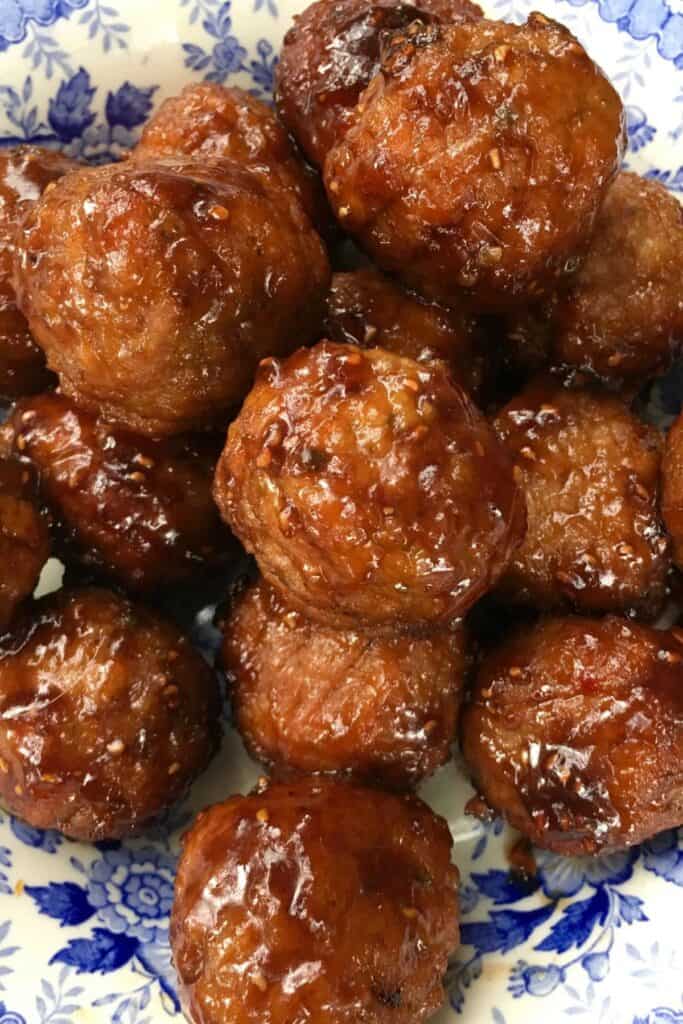 Raspberry balsalmic glazed meatballs in a blue and white dish.