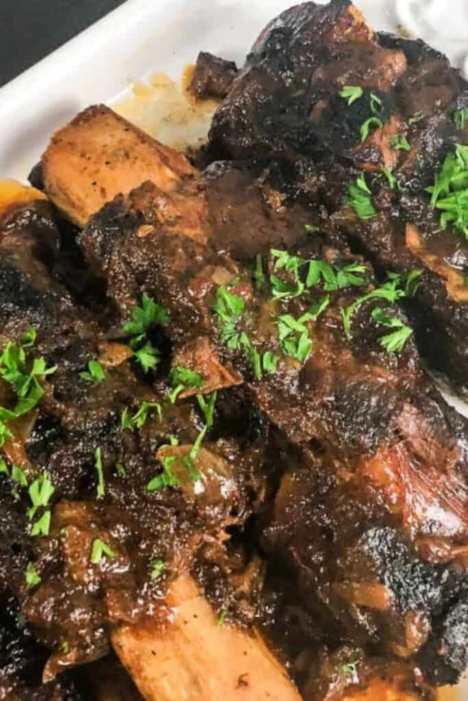 ribs with chipotle meatballs and sprinkled parsley on a white plate.
